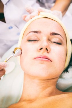 Yüz germe. Genç kadın. Yüz Cilt Bakımı. Yordam kaldırma. Cos