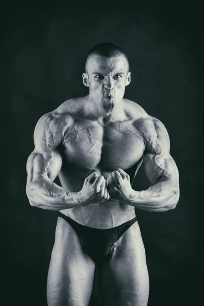 Bodybuilder auf dunklem Hintergrund. — Stockfoto