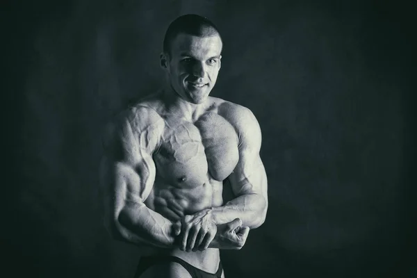 Bodybuilder  on a dark background. — Stock Photo, Image