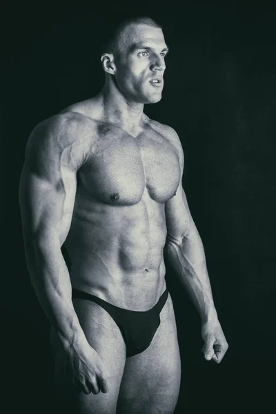 Bodybuilder sur fond sombre . — Photo