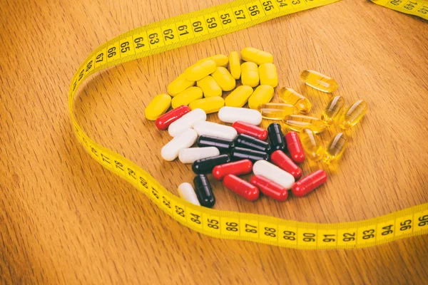 Diferentes pílulas e pílulas em um fundo de madeira — Fotografia de Stock