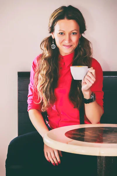 Het meisje is het drinken van cappuccino — Stockfoto