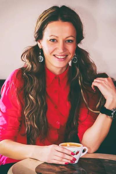 Het meisje is het drinken van cappuccino — Stockfoto