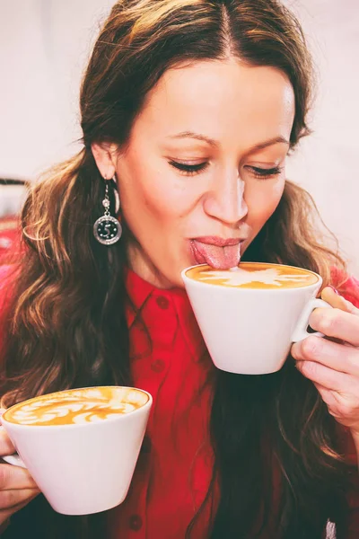 Het meisje is het drinken van cappuccino — Stockfoto
