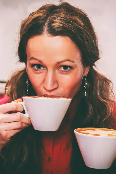 The girl is drinking cappuccino — Stock Photo, Image