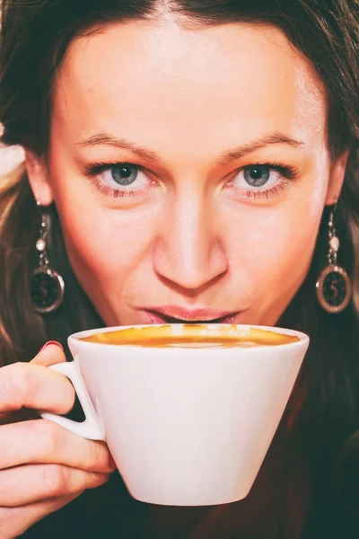 The girl is drinking cappuccino — Stock Photo, Image