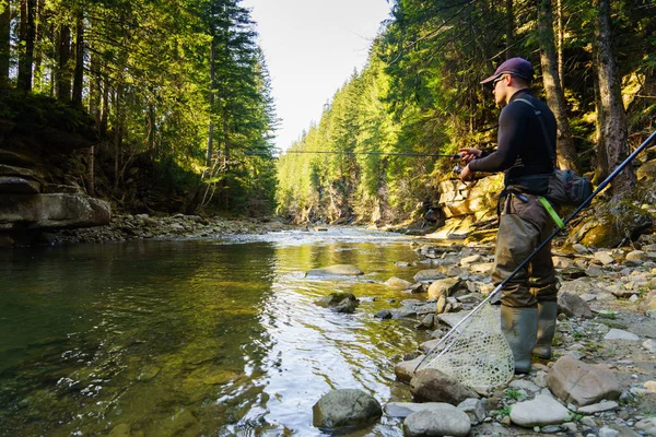 Fischer an einem schönen Gebirgsfluss im Wald — Stockfoto