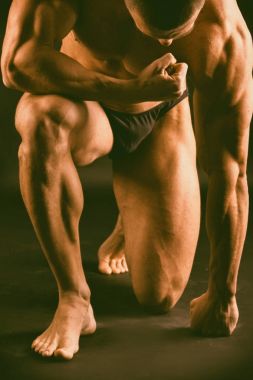 Siyah bir arka plan üzerinde kas, kabartma vücut geliştirmeci