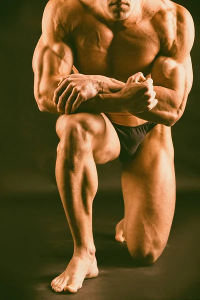 Muskulöser, reliefartiger Bodybuilder auf schwarzem Hintergrund — Stockfoto
