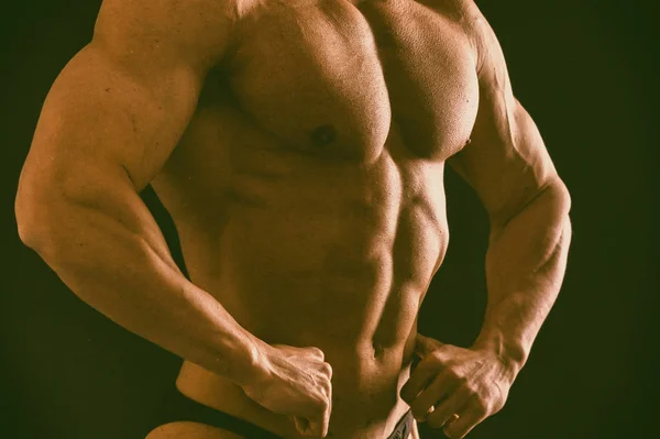 Muscular, levantador de pesas en relieve sobre un fondo negro — Foto de Stock