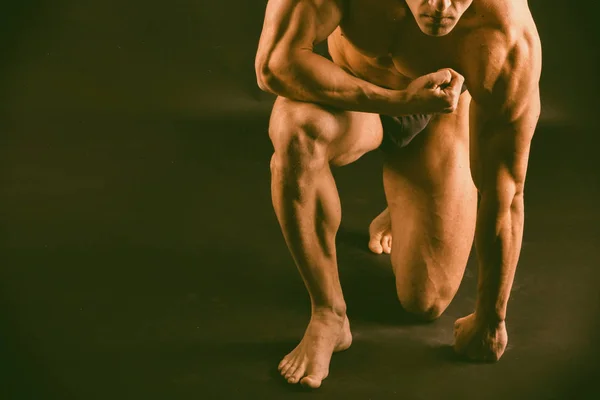 Muscular, fisiculturista alívio em um fundo preto — Fotografia de Stock