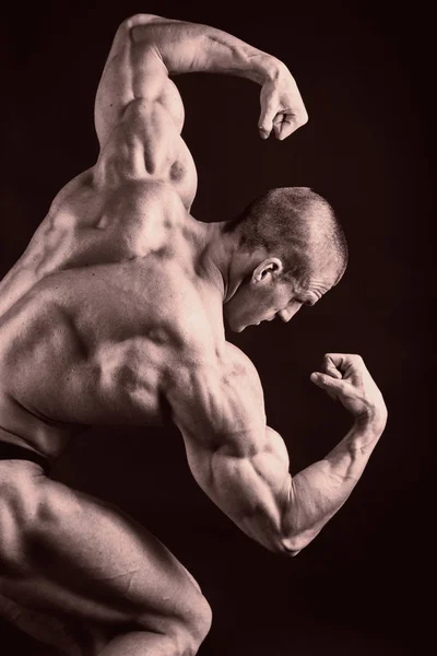 Bodybuilder på svart — Stockfoto