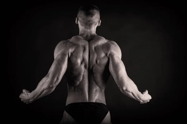 Bodybuilder  on a dark background. — Stock Photo, Image