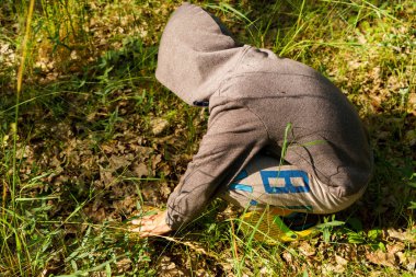 Çocuk ormanda mantar toplar