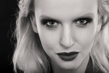 Siyah arka planda güzel, seksi sarışın kadın.