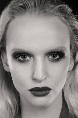 Siyah arka planda güzel, seksi sarışın kadın.