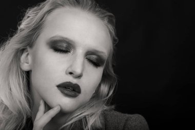 Siyah arka planda güzel, seksi sarışın kadın.