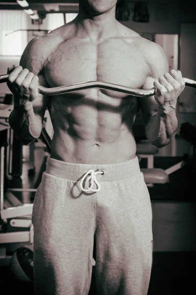 Spor salonunda egzersiz yapan kaslı bir adam. — Stok fotoğraf