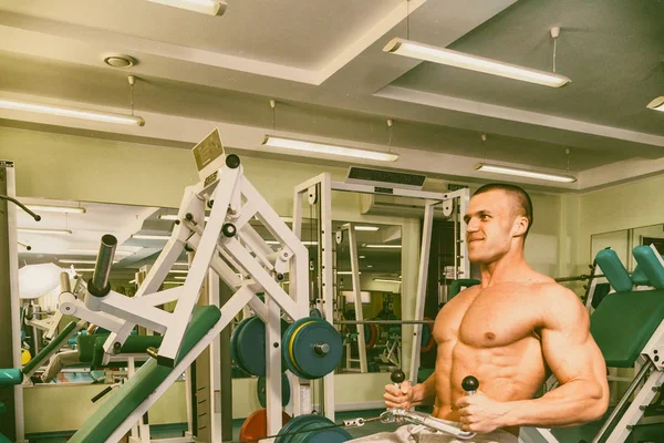 Spor salonunda egzersiz yapan kaslı bir adam. — Stok fotoğraf