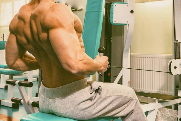 Muskulös man tränar i gym gör övningar — Stockfoto