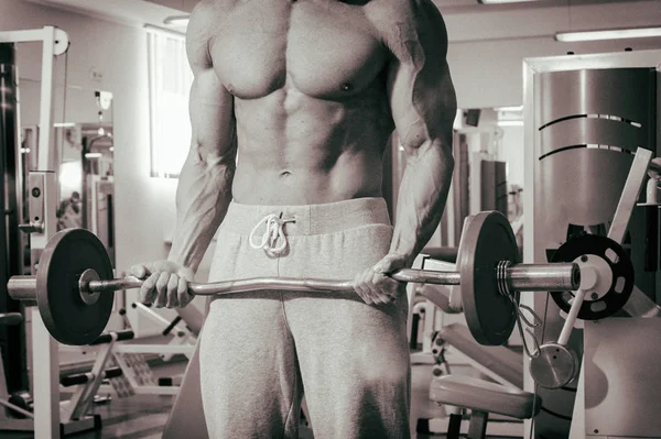 Musculoso hombre haciendo ejercicio en el gimnasio haciendo ejercicios — Foto de Stock