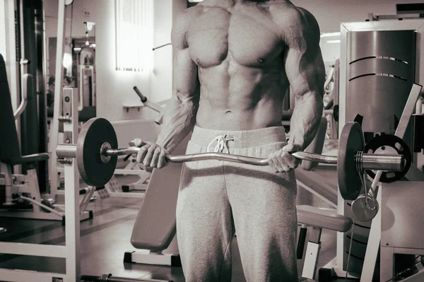 Spor salonunda egzersiz yapan kaslı bir adam. — Stok fotoğraf