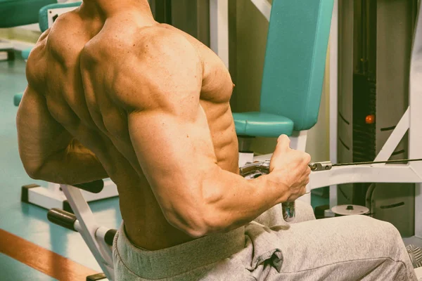 Muskulöser Mann trainiert im Fitnessstudio bei Übungen — Stockfoto