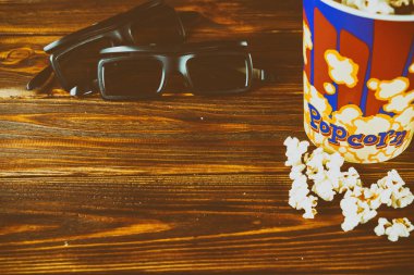 Patlamış mısır ve ahşap arka plan üzerinde 3d film izlemek için gözlük. Tonda fotoğraf