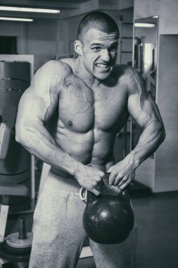 Spor salonunda eğitim ve kas poz kaslı adam vücut geliştirmeci