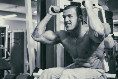 Spor salonunda eğitim ve kas poz kaslı adam vücut geliştirmeci