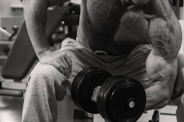 Spor salonunda eğitim ve kas poz kaslı adam vücut geliştirmeci