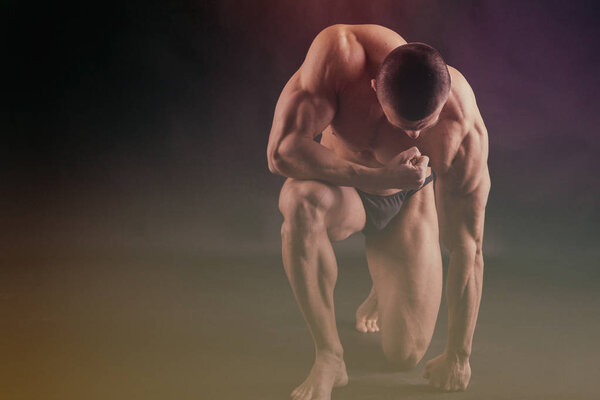 Мускулистый человек бодибилдер тренировки в тренажерном зале и позирования мышц
