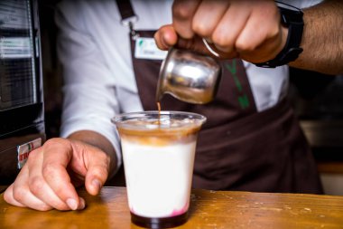 Barista kafenin arka planında kahve yapıyor.