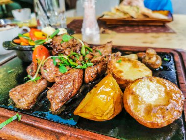 Biftek ve patates arka planda.