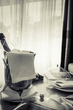 Masada bir kova şampanya ve meyve var.