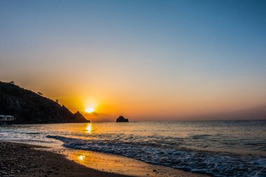 Gündoğumu kumsalda deniz