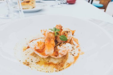 Karides, beyaz plaka seyahatinin arka planında pişiyor.