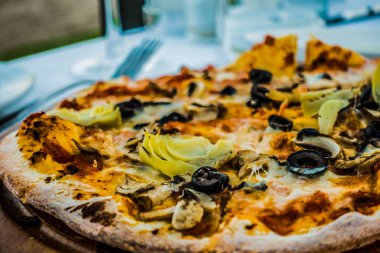 Restoranın arka planında pizza.