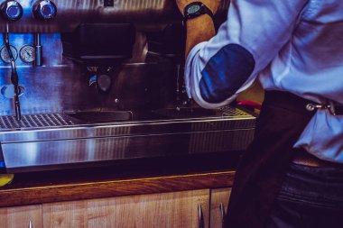 Barista kafenin arka planında kahve yapıyor.