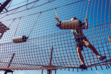 Çocuk ip parkında oynuyor.