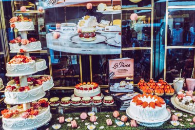 Resimli bir caddede üzerinde pastalar olan güzel bir vitrin.