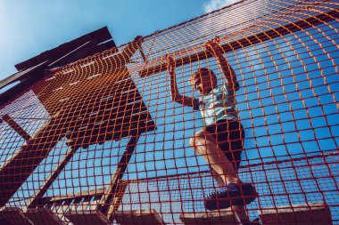 Çocuk ip parkında oynuyor.