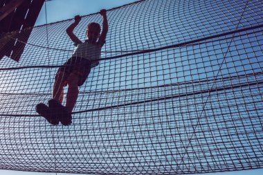 Çocuk ip parkında oynuyor.