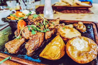 Biftek ve patates arka planda.