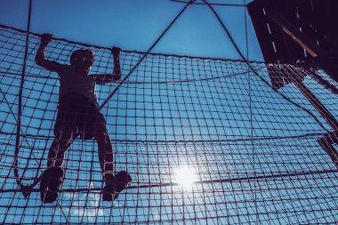 Çocuk ip parkında oynuyor.