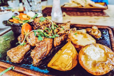 Biftek ve patates arka planda.