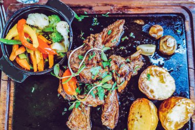 Biftek ve patates arka planda.