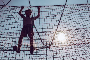 Çocuk ip parkında oynuyor.