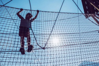 Çocuk ip parkında oynuyor.