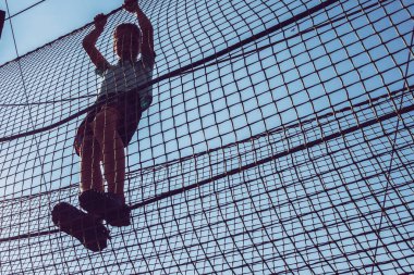 Çocuk ip parkında oynuyor.